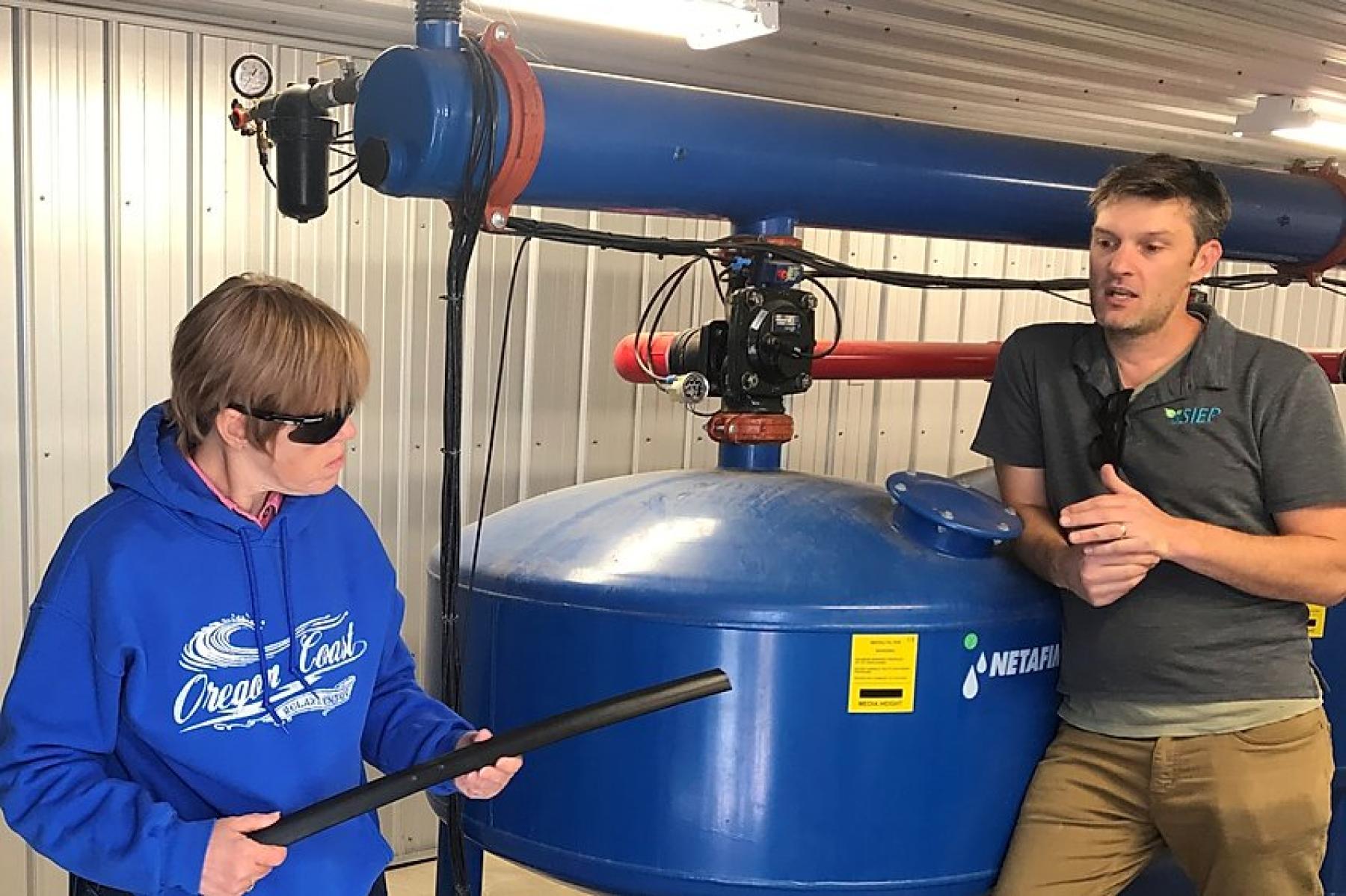 Jason VonLembke, right, who oversees the Subsurface Irrigation Efficiency Project, explains how an irrigation tape works to Jackie Jones of Kersey during an open house Oct. 5.