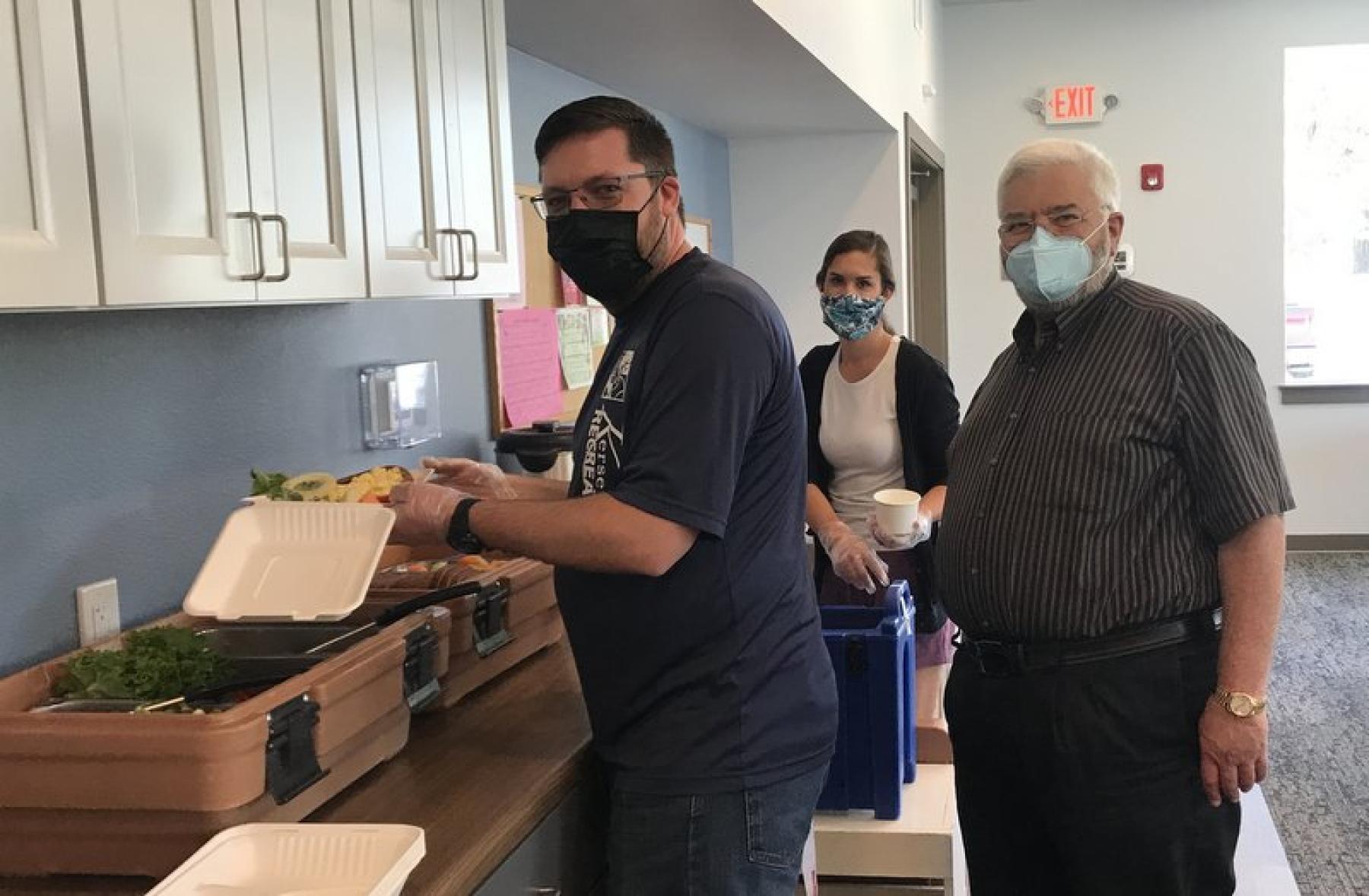 70 Ranch owner Bob Lembke, right, watches as town of Kersey workers package meals for seniors. 